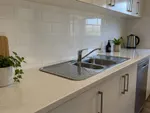 Example work photo: a spotless kitchen benchtop and splashback