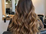 Example work photo: a caramel balayage on long wavy hair