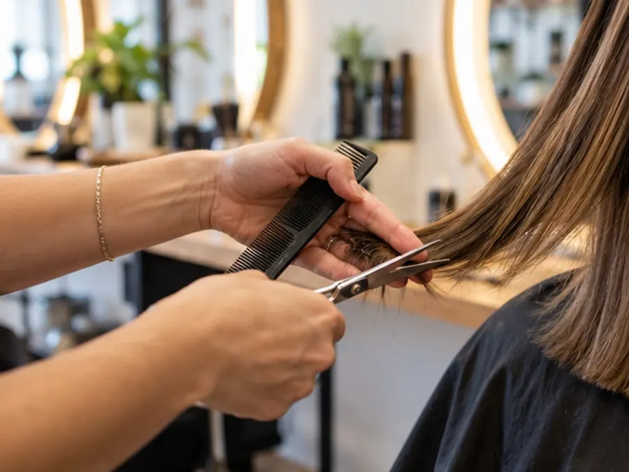 A hairdresser mid-cut with scissors and comb